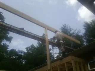 Carpenter setting a ridge beam over a new addition frame — Ice Dam Removal by Roofing Brothers in Three Forks