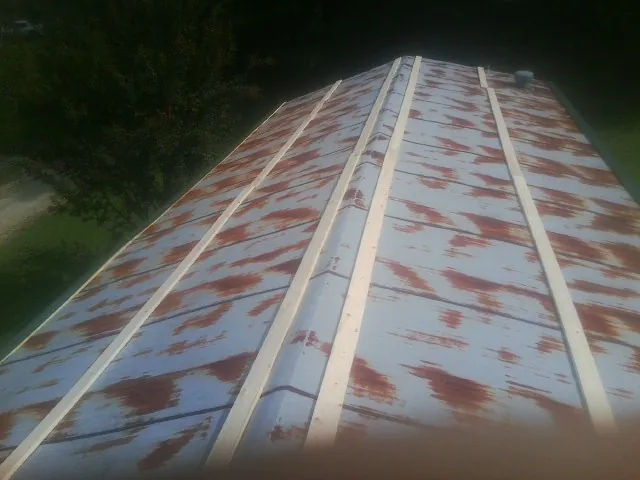 Rusted metal roof panels with new wood purlins before replacement — Storm Damage Roof Repair in Three Forks by Roofing Brothers